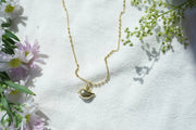 sparrow bird necklaced displayed on cloth beside flowers